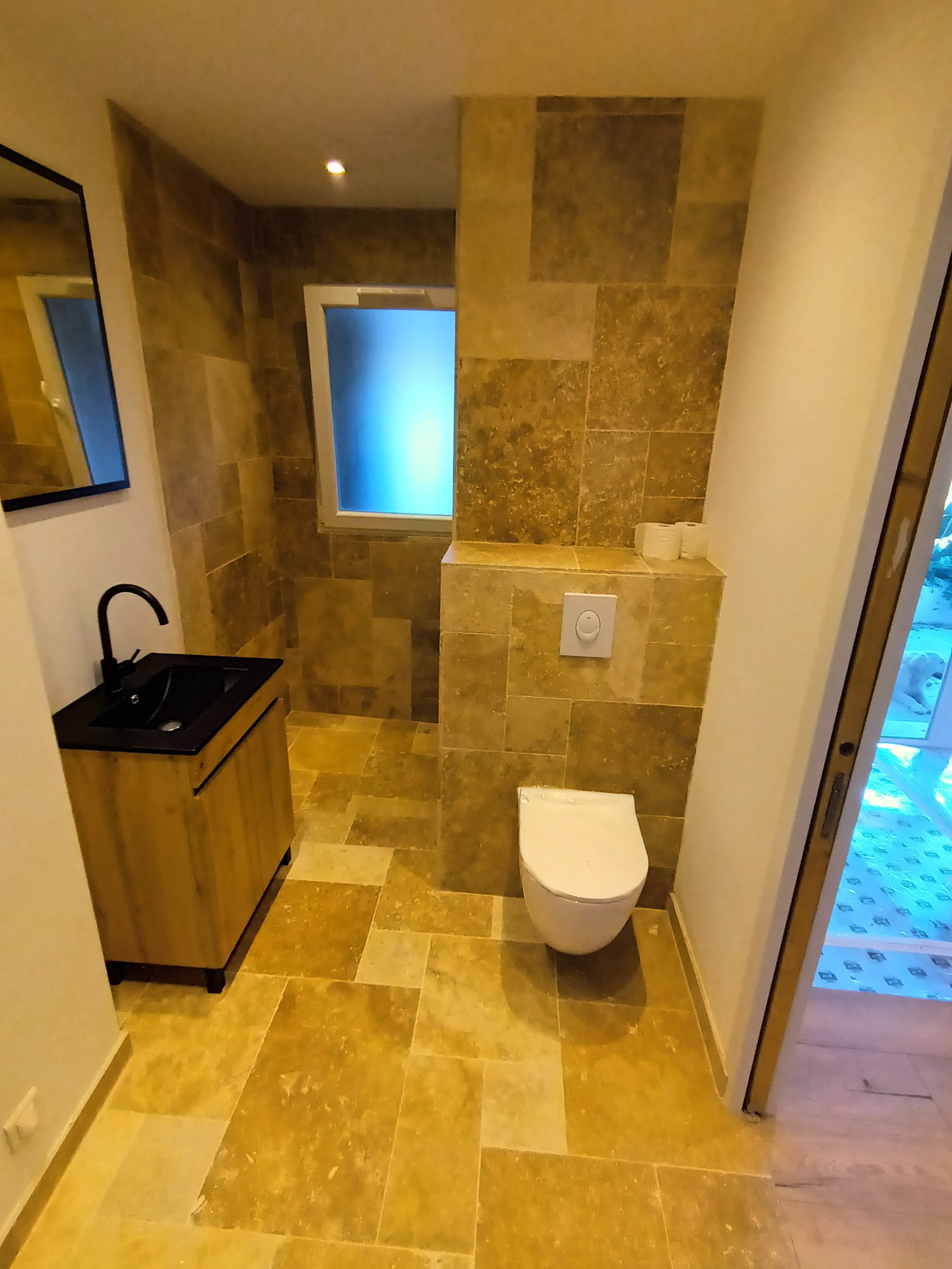 Salle de bain rénovée avec des carreaux en pierre et un lavabo moderne