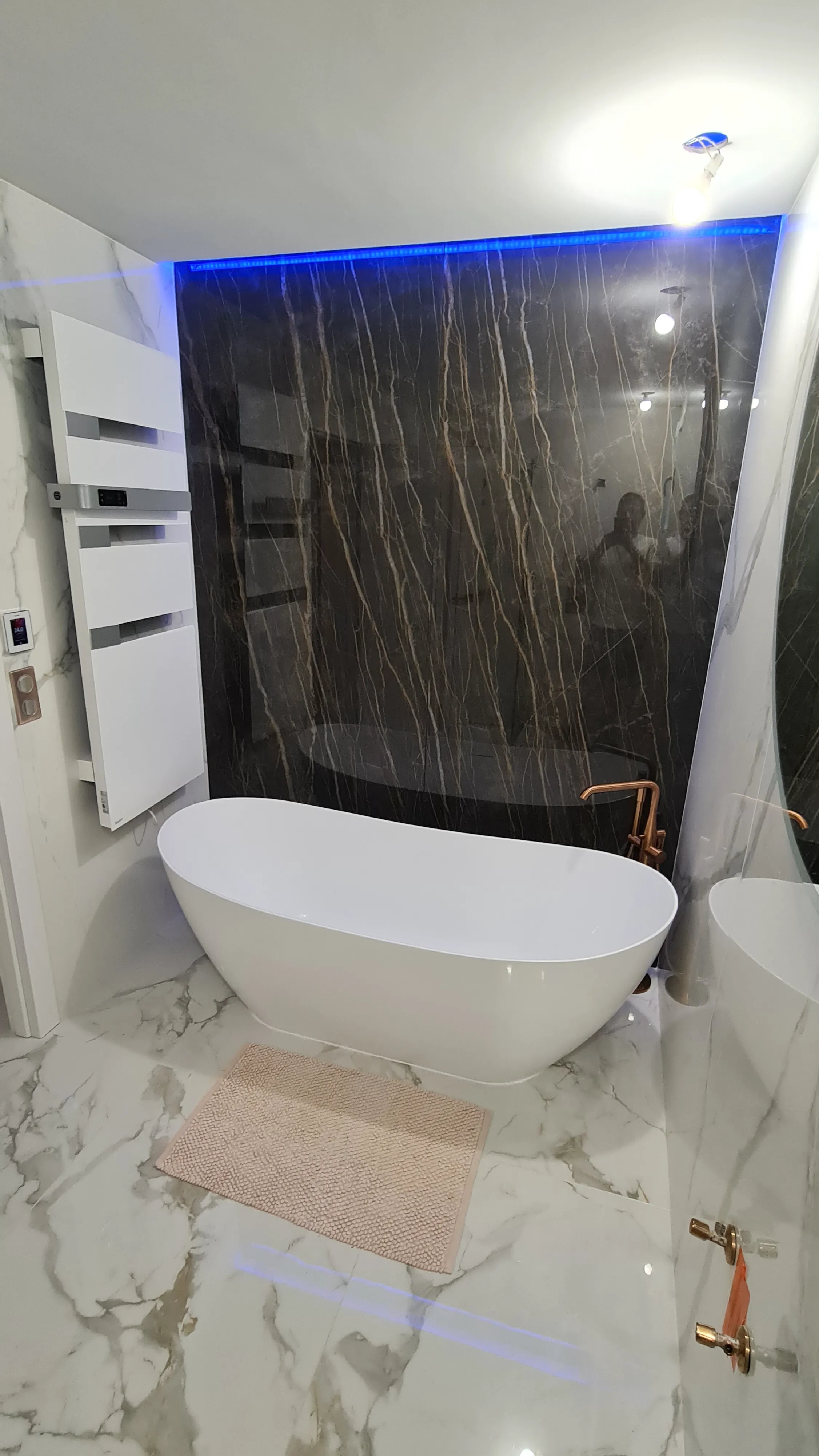 Salle de bain moderne avec baignoire design et murs en marbre