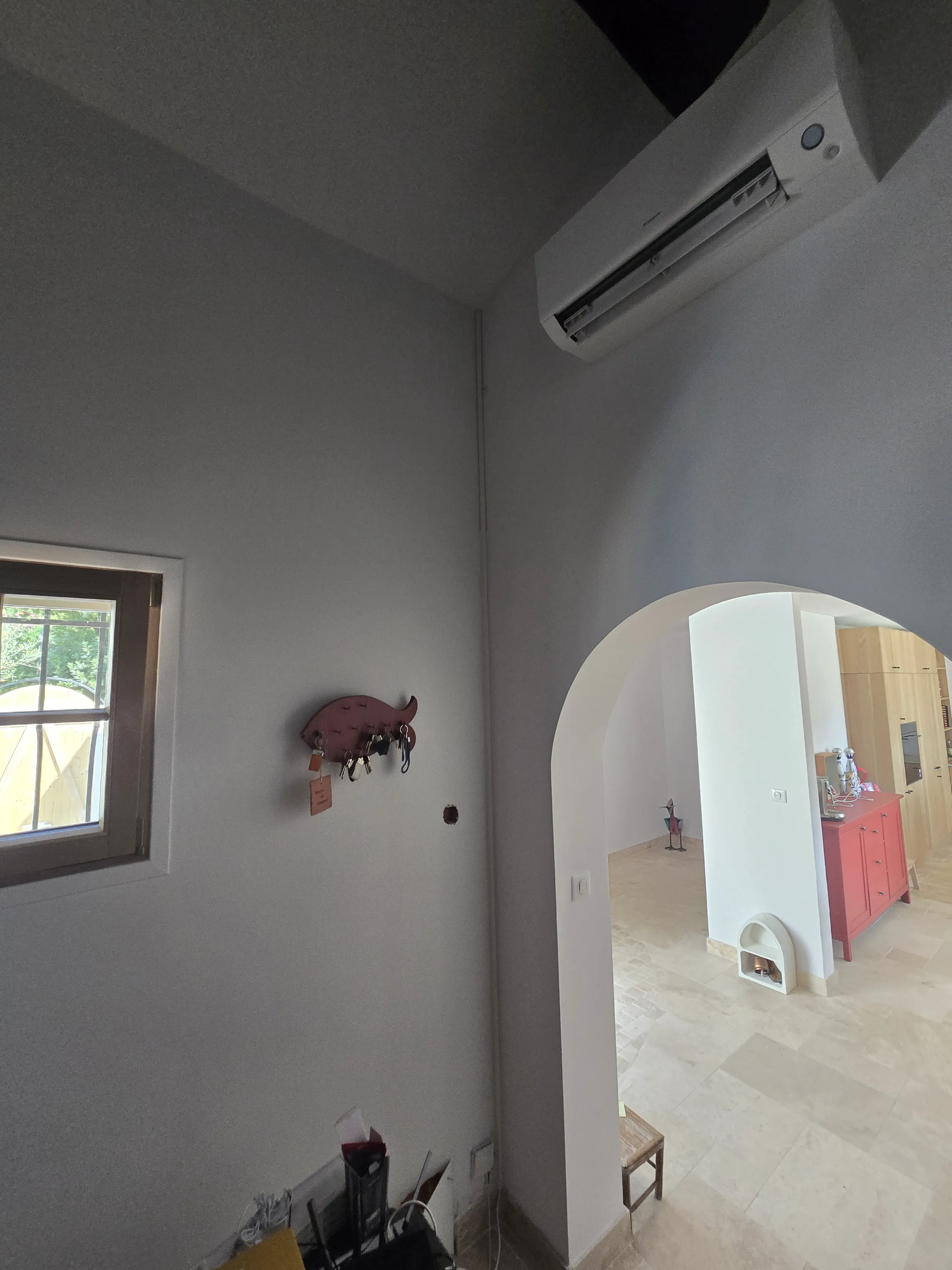 Détail d'une pièce avec un mur éclairé, climatisation et espace de vie rénové