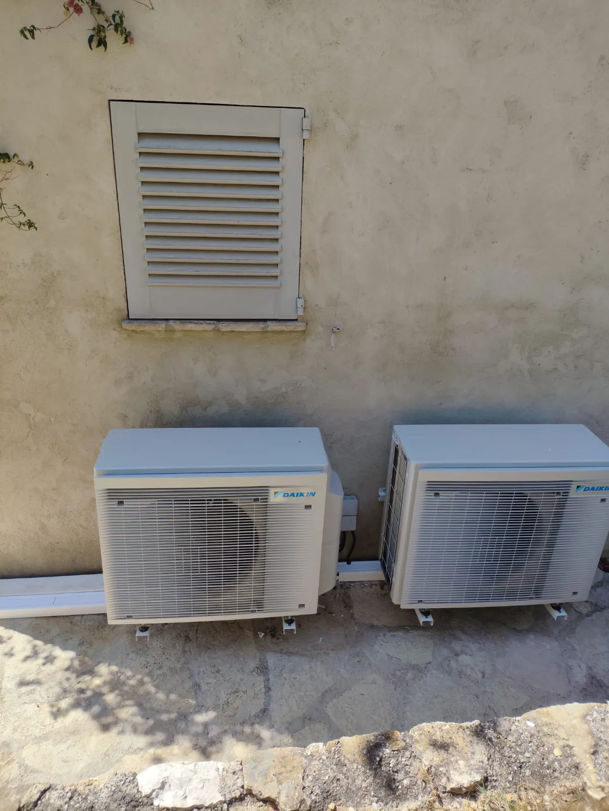 Systèmes de climatisation installés sur un mur extérieur beige
