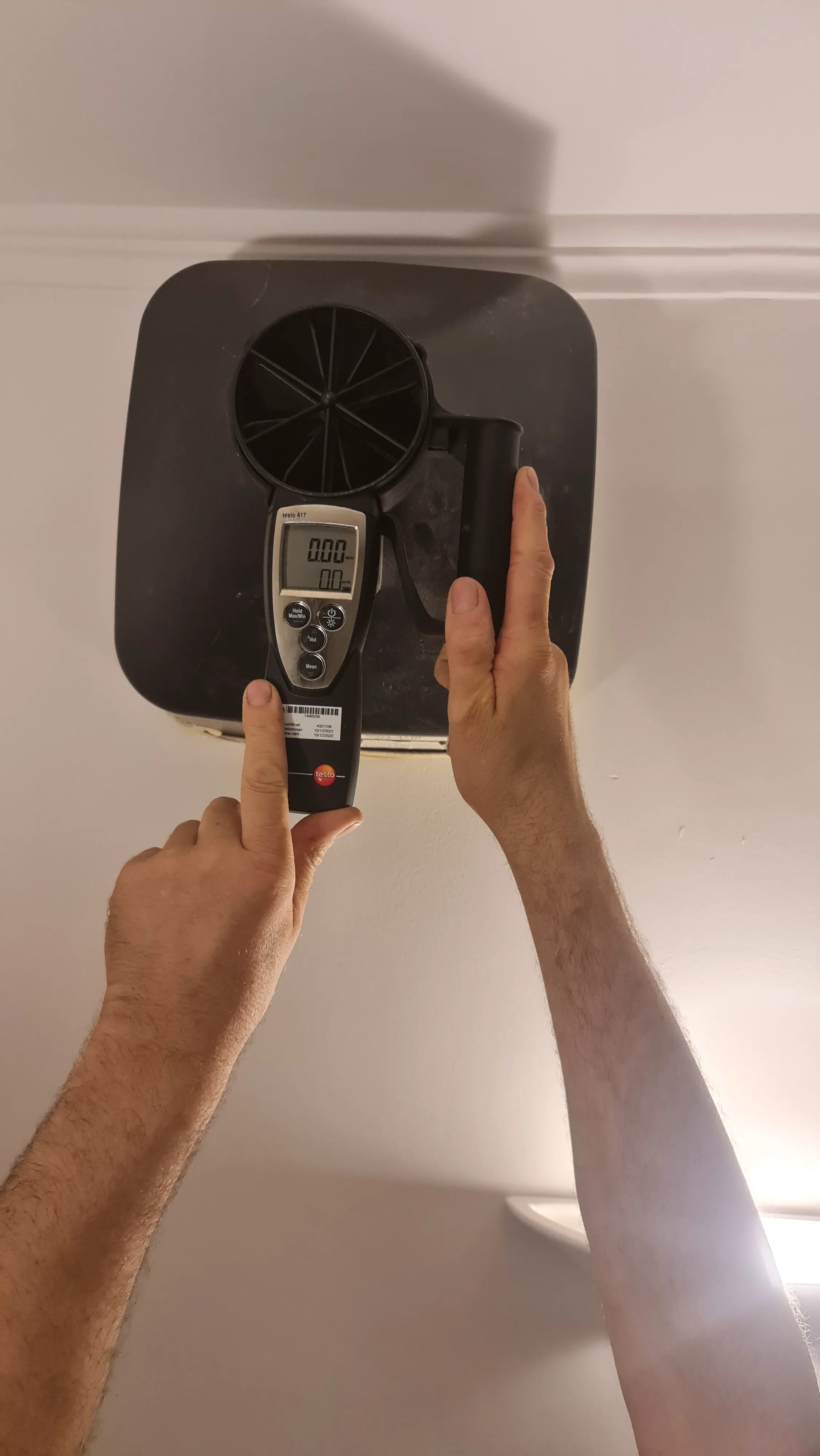 Technicien vérifiant un système de ventilation avec un appareil de mesure